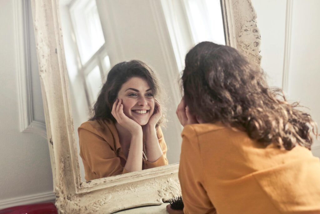 Autostima: 5 Strategie Efficaci per Rafforzarla e Migliorare le Relazioni 6 Persona sorridente che si guarda allo specchio – simbolo di autostima e consapevolezza di sé nelle relazioni